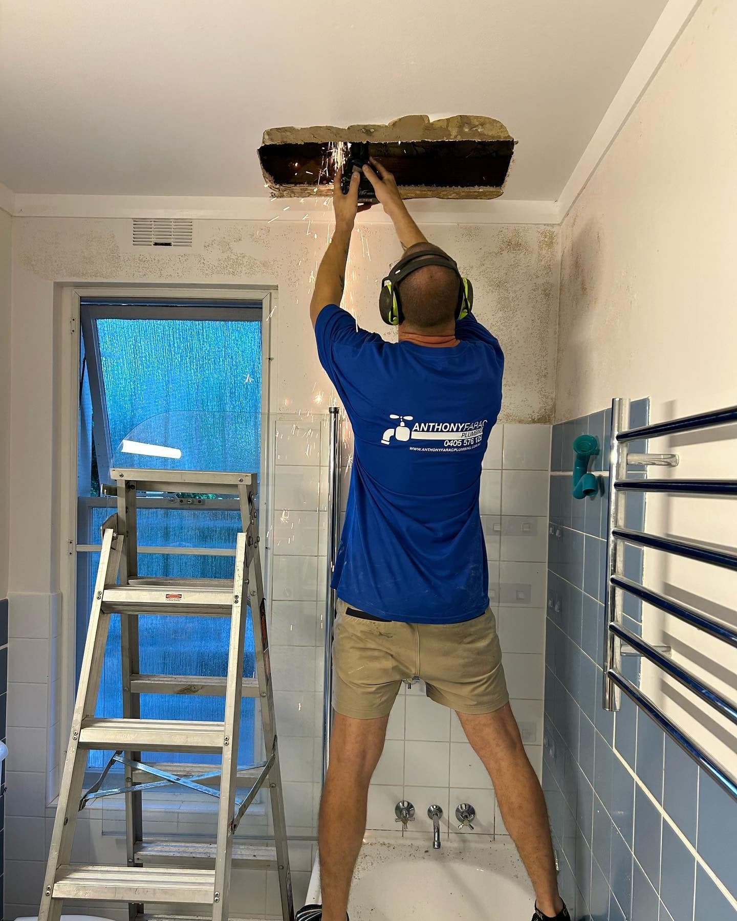 AFP plumber fixing leaking pipe in bathroom ceiling, Lane Cove